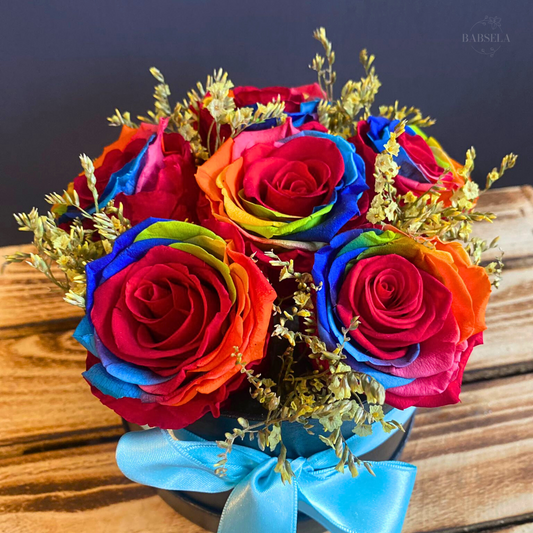 Bouquet of vibrant rainbow roses in a decorative arrangement with a blue ribbon