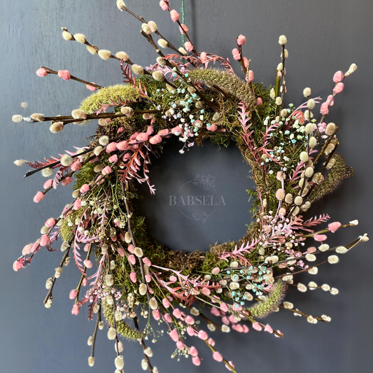 Handcrafted wreath featuring pink and white pussy willow branches, greenery, and delicate dried florals, designed by Babsela