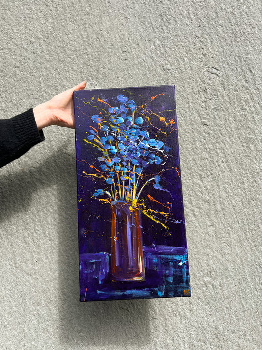 Hand holding a vibrant blue floral painting in a vase with an abstract background, perfect for home decor